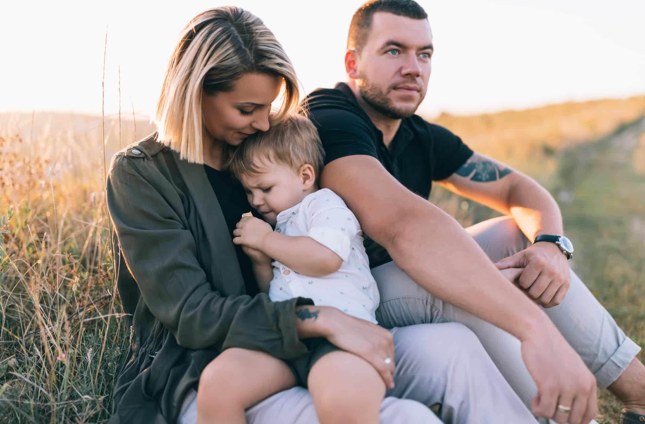 beautiful happy family with one child sitting together outdoors