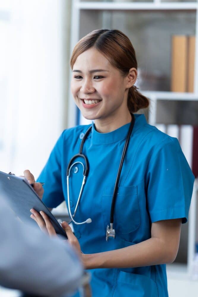 Nurse and patient sitting and talking at medical examination at medical office.